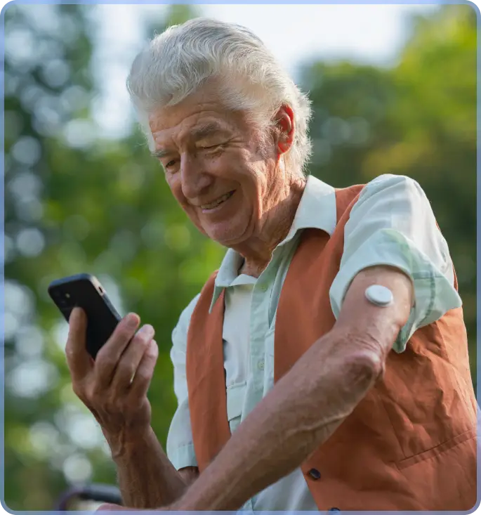 Old man wearing CGM patch and holding his smartphone